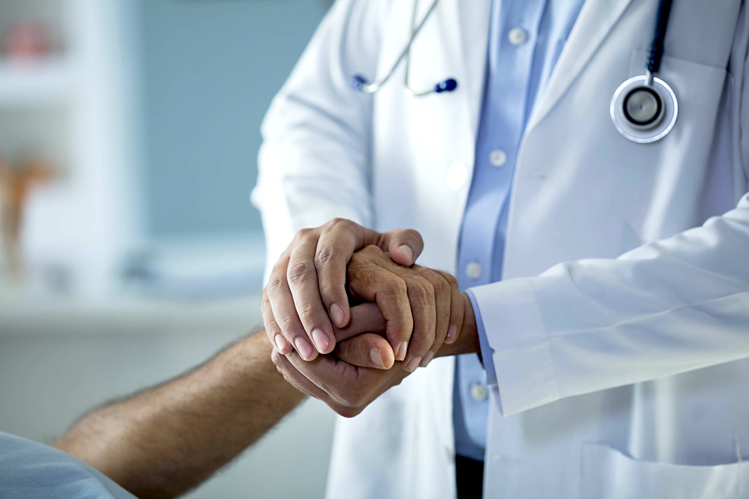 A doctor holding a patient's hands
